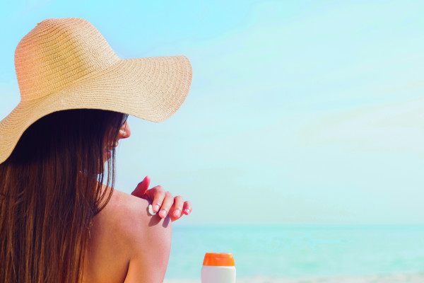 Woman applies sunscreen