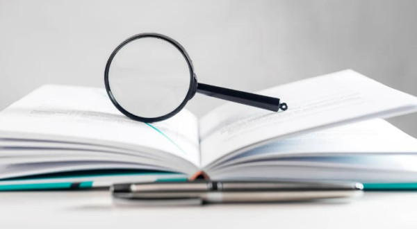 A magnifying glass with books