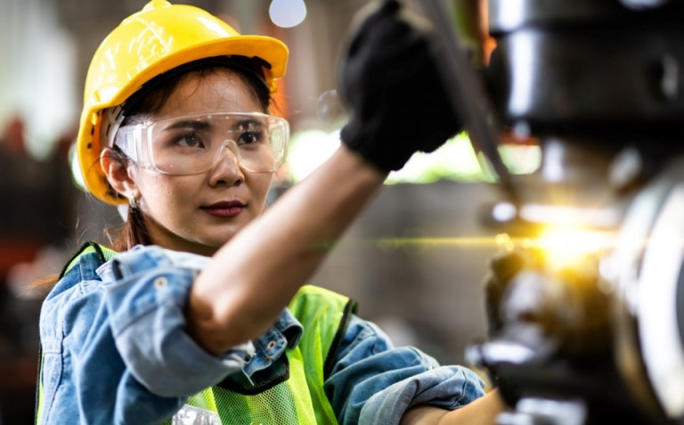 woman in ppe using machinery