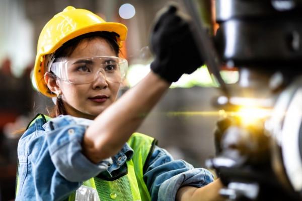 Woman in PPE using machinery